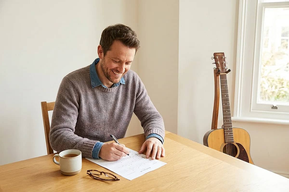 A guitar teacher preparing a worksheet with tab and standard notation